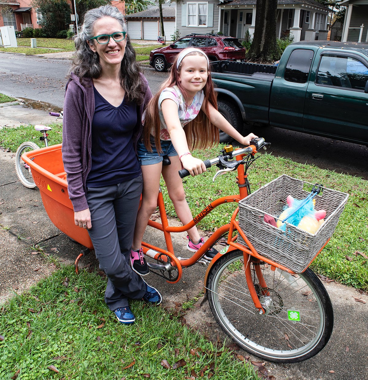 Woman and girl standing near bike.